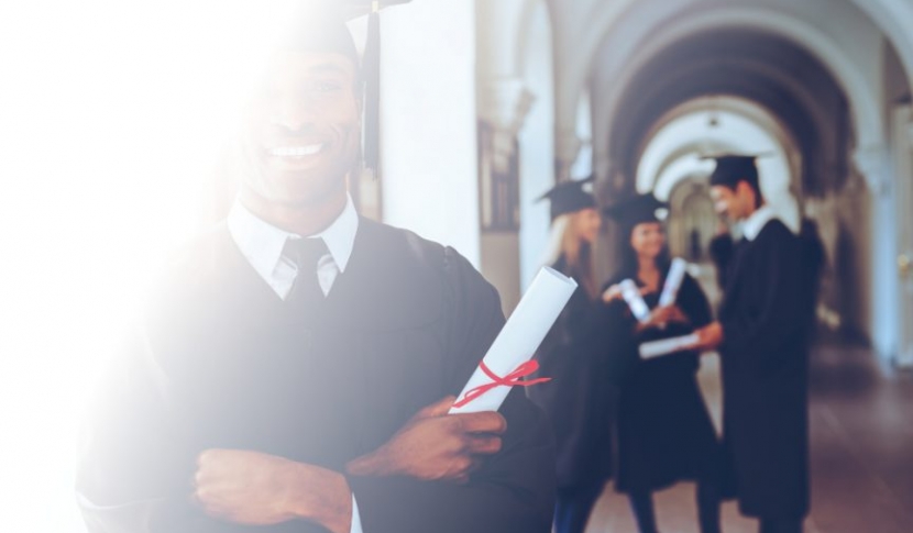 man in cap and gown at graduation