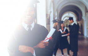 man in cap and gown at graduation 